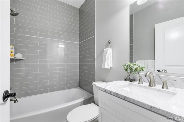 full bathroom with vanity, tiled shower / bath, and toilet