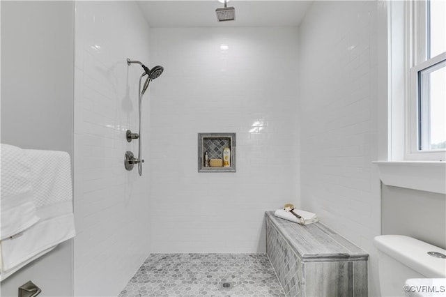 bathroom featuring toilet and tiled shower