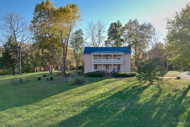 view of front of house featuring a front yard and a balcony