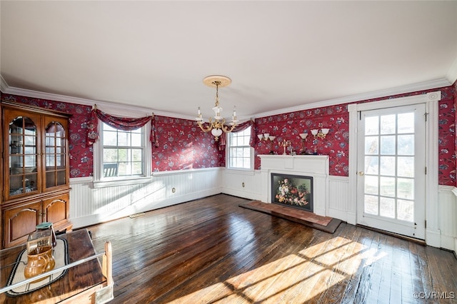 unfurnished living room with ornamental molding, hardwood / wood-style floors, and a healthy amount of sunlight