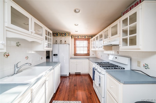 kitchen featuring dark wood-type flooring, sink, white cabinets, white appliances, and tasteful backsplash