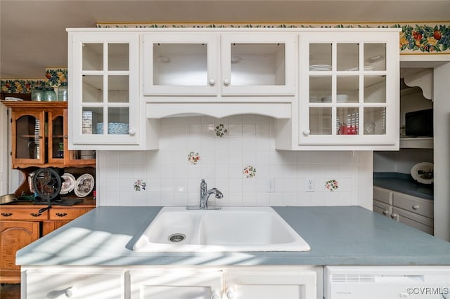 kitchen with white cabinets, tasteful backsplash, sink, and dishwasher