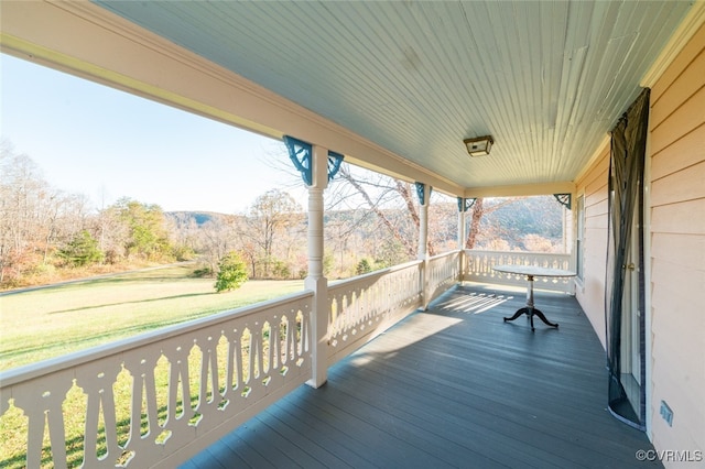 wooden terrace with a porch and a lawn