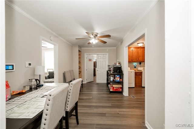 dining space with ornamental molding, dark wood-type flooring, washer and clothes dryer, and ceiling fan