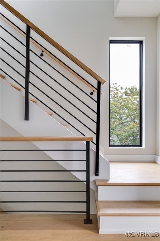 stairs with hardwood / wood-style flooring and plenty of natural light