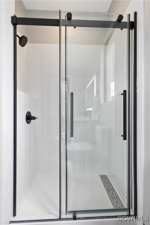 bathroom with a shower with door