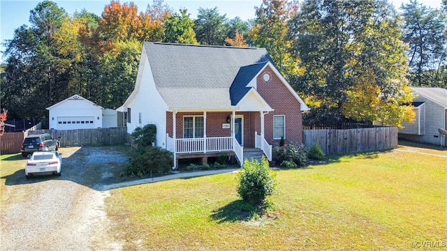 view of front facade with an outdoor structure, a front yard, covered porch, and a garage