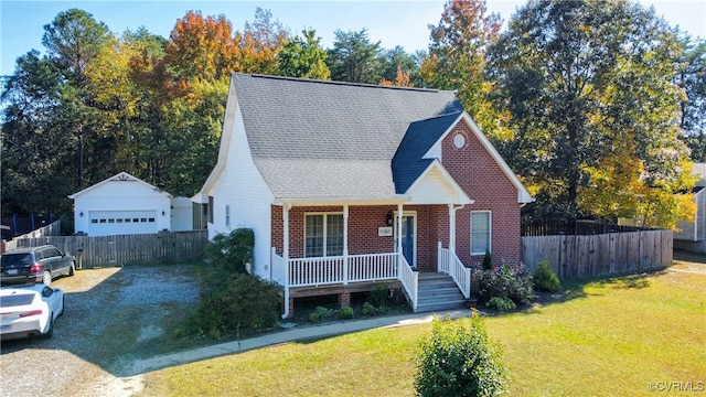 view of front of property featuring a front yard, an outdoor structure, a garage, and a porch