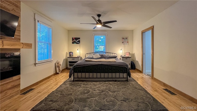 bedroom with radiator, light hardwood / wood-style floors, and ceiling fan