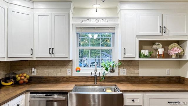 kitchen featuring decorative backsplash, white cabinetry, dishwasher, butcher block counters, and sink