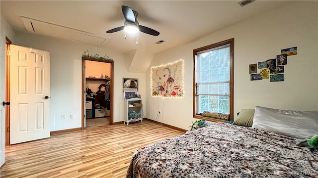 bedroom with a spacious closet, ceiling fan, a closet, and light hardwood / wood-style floors