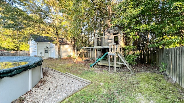 view of yard with a playground and a covered pool