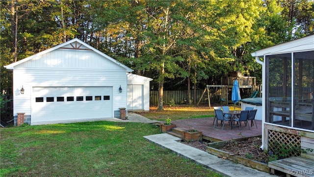 view of yard with an outbuilding, a wooden deck, a garage, and a sunroom