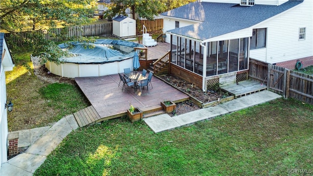 view of yard with a storage shed, a pool side deck, and a sunroom