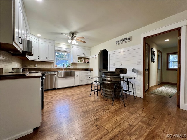 kitchen with light hardwood / wood-style flooring, white cabinets, sink, and ceiling fan