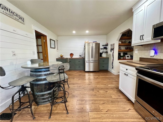 kitchen featuring white cabinetry, stainless steel appliances, wood counters, and light wood-type flooring