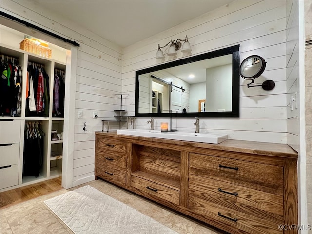 bathroom featuring vanity, hardwood / wood-style floors, and wooden walls