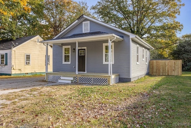 bungalow-style home featuring a front lawn and covered porch