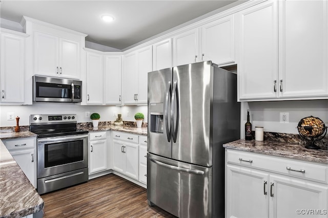 kitchen featuring white cabinets, dark stone counters, stainless steel appliances, and dark wood-type flooring