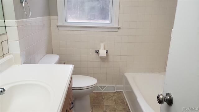 bathroom featuring tile walls, vanity, toilet, and tile patterned flooring