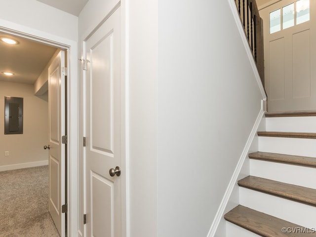 stairs featuring electric panel and carpet