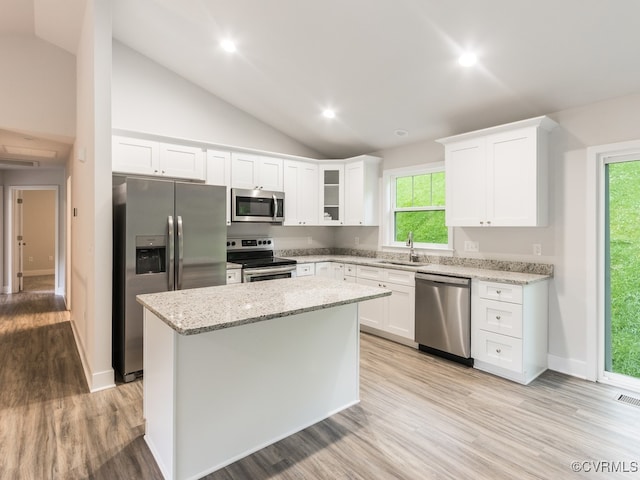 kitchen with lofted ceiling, sink, white cabinets, and stainless steel appliances