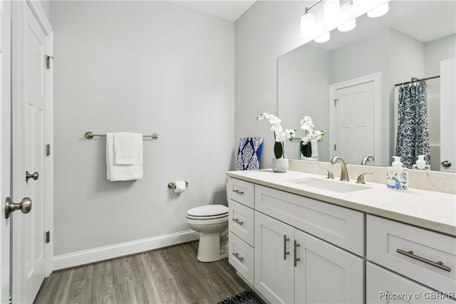 bathroom with vanity, hardwood / wood-style floors, curtained shower, and toilet