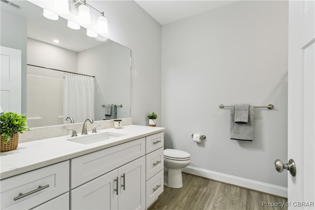 bathroom featuring vanity, hardwood / wood-style flooring, toilet, and a shower with shower curtain