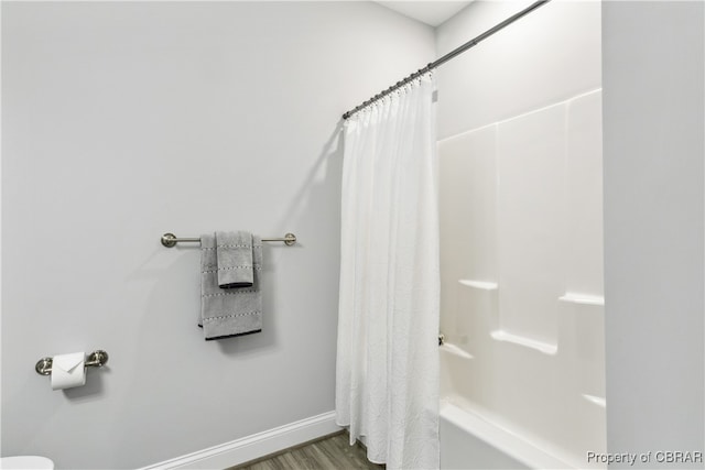 bathroom featuring hardwood / wood-style flooring and shower / bath combination with curtain