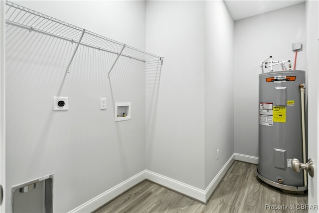 clothes washing area featuring hookup for an electric dryer, water heater, hardwood / wood-style flooring, and hookup for a washing machine