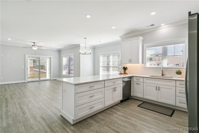 kitchen with sink, kitchen peninsula, decorative light fixtures, and white cabinets