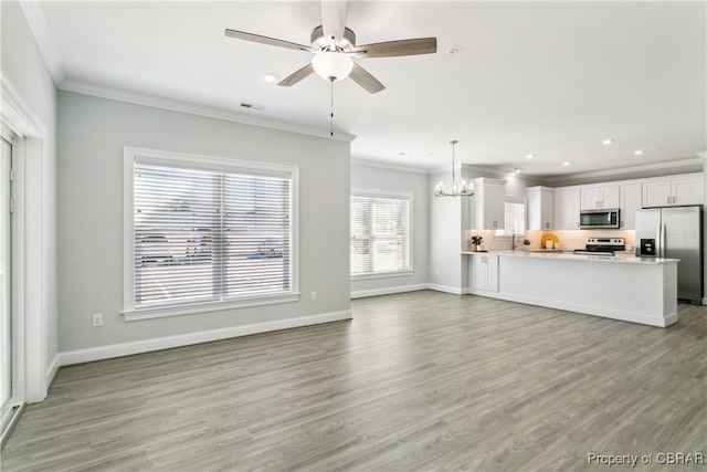 unfurnished living room with crown molding, light wood-type flooring, and ceiling fan with notable chandelier