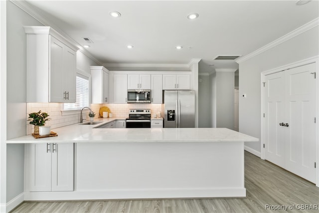 kitchen featuring sink, light wood-type flooring, white cabinetry, stainless steel appliances, and crown molding