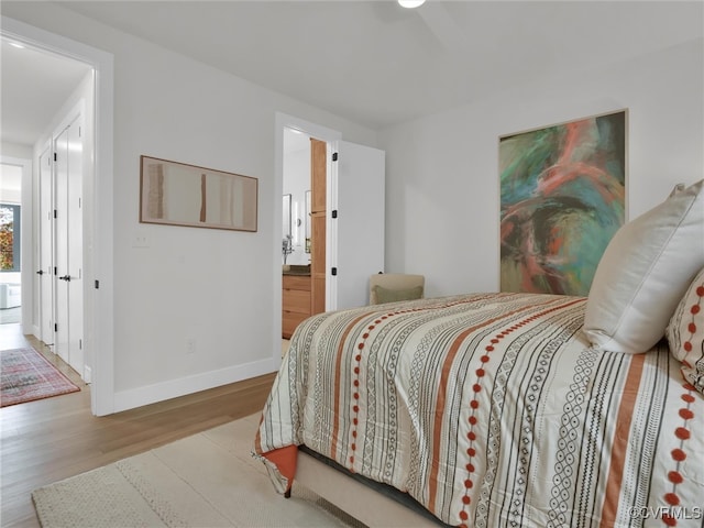 bedroom featuring hardwood / wood-style flooring and connected bathroom