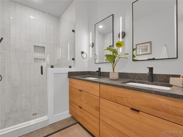 bathroom with tile patterned flooring, vanity, and a shower with shower door