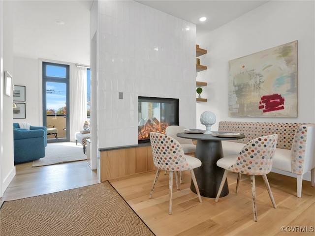 dining space featuring light wood-type flooring and a fireplace