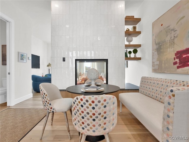 dining room with a fireplace and light hardwood / wood-style flooring