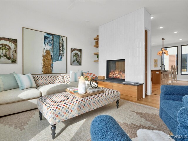 living room featuring a large fireplace and light wood-type flooring