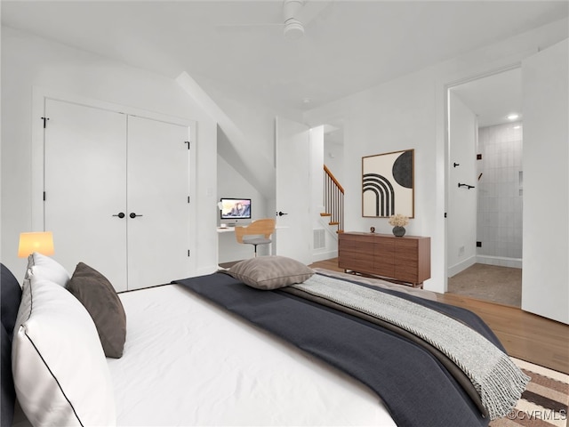 bedroom with a closet, hardwood / wood-style floors, ensuite bath, and ceiling fan