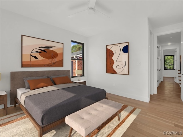 bedroom with light hardwood / wood-style floors and ceiling fan