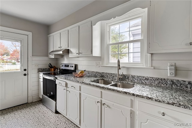 kitchen featuring electric range, plenty of natural light, and white cabinets