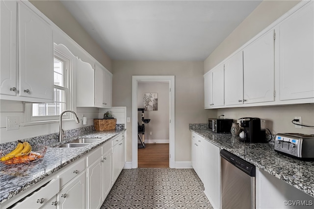 kitchen with stone counters, stainless steel appliances, white cabinetry, and sink