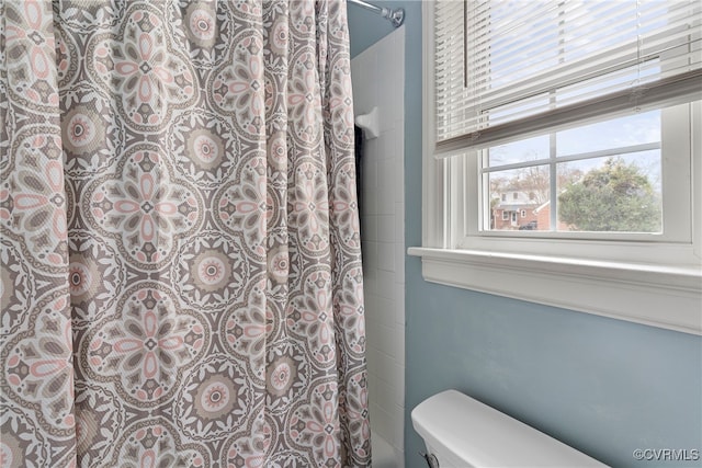 bathroom with curtained shower and toilet