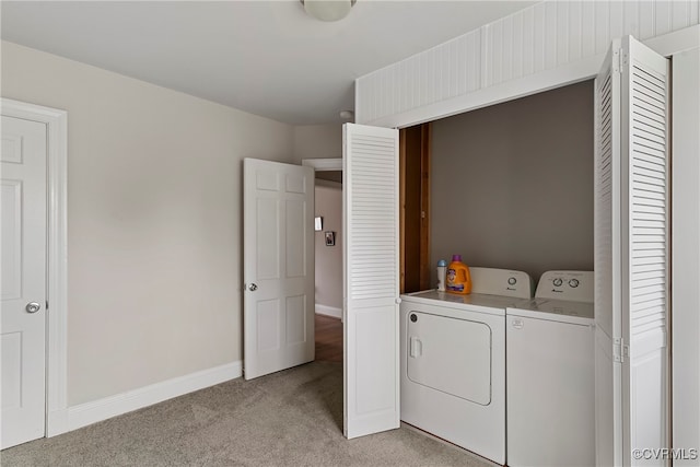 laundry area featuring washer and clothes dryer and light carpet