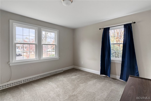 carpeted empty room with baseboard heating