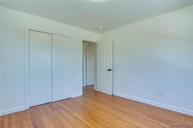 unfurnished bedroom featuring light wood-type flooring and a closet