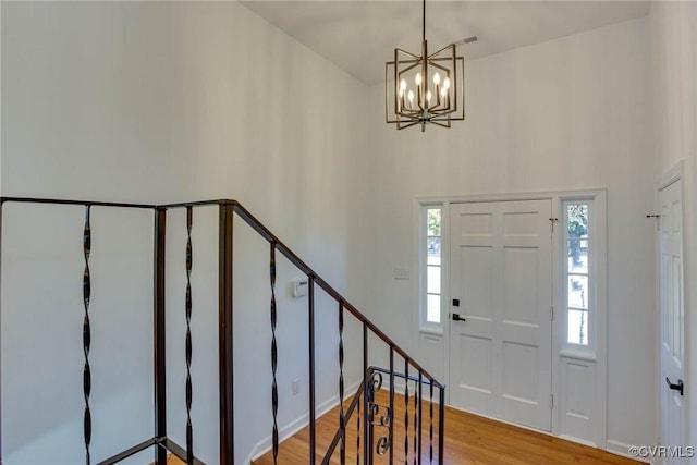 foyer featuring light wood-type flooring and a notable chandelier