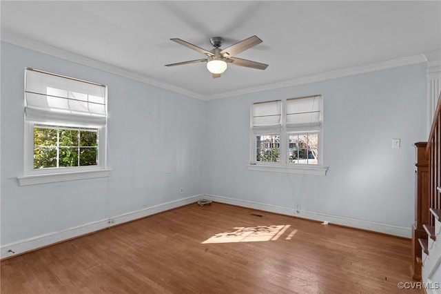 empty room featuring ornamental molding, hardwood / wood-style floors, and a healthy amount of sunlight