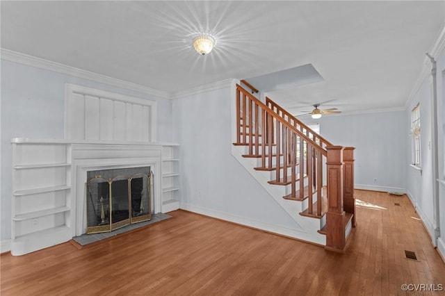 unfurnished living room with ceiling fan, hardwood / wood-style flooring, and crown molding