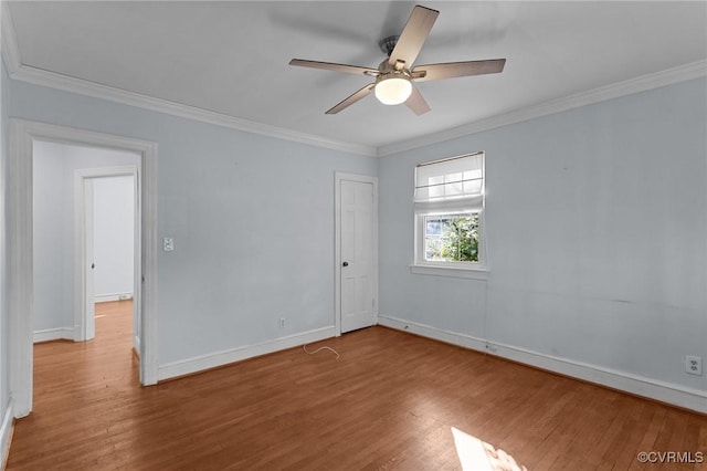 empty room featuring ceiling fan, wood-type flooring, and ornamental molding